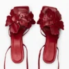 Sandalen mit Blumenapplikationen